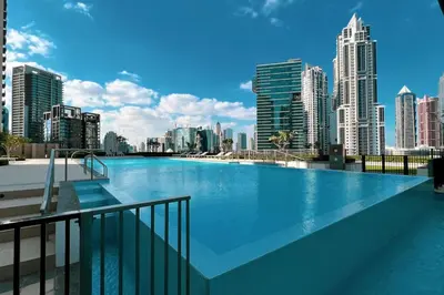 a large swimming pool with a view of a city at Mahogany 7 - 2BR 6PAX - Walk to Burj & Dubai Mall in Dubai