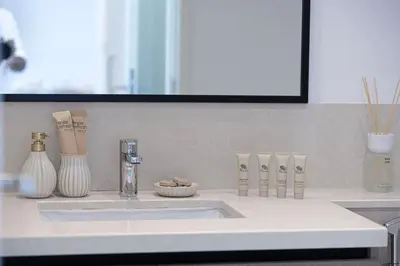 a bathroom counter with a sink and vases on it at Mahogany 7 - 2BR 6PAX - Walk to Burj & Dubai Mall in Dubai