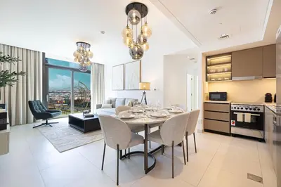 a kitchen and living room with a table and chairs at Mahogany 7 - 2BR 6PAX - Walk to Burj & Dubai Mall in Dubai