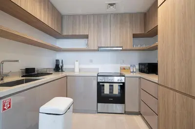 a small kitchen with a stove and a sink at Mahogany 5 - 2BR 6PAX - Infinity Pool & High-floor in Dubai