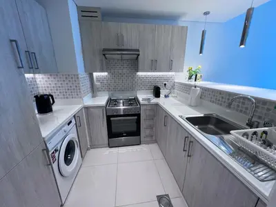 a small kitchen with a stove and a sink at Stunning 1 bedroom apartment in Seven Palm Dubai in Dubai