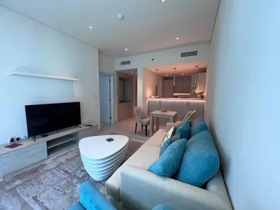 a living room with a couch and a television at Stunning 1 bedroom apartment in Seven Palm Dubai in Dubai