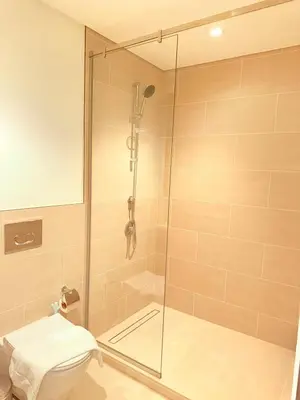 a bathroom with a shower and a toilet at 1 Bed With Private Beach Access In Dubai Creek Harbour in Dubai