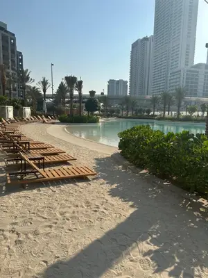 a beach with benches and water in a city at 1 Bed With Private Beach Access In Dubai Creek Harbour in Dubai