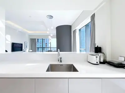 a kitchen with white counters and a sink at 2BR Apartment in Paramount Tower in Dubai
