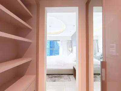 a room with a bedroom with a bed and a mirror at 2BR Apartment in Paramount Tower in Dubai