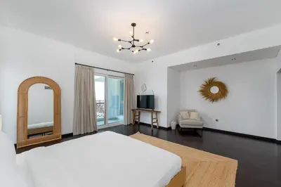 a white bedroom with a bed and a mirror at Marina Residence 4, Palm Jumeirah - Mint Stay in Dubai