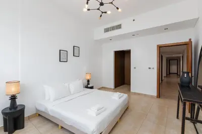 a bedroom with a large white bed and a table at Marina Residence 4, Palm Jumeirah - Mint Stay in Dubai