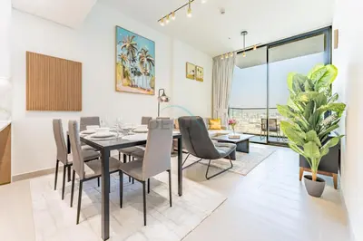 a dining room and living room with a table and chairs at Skyline and Community Views 1BR with Private Balcony Near Community Park, Binghatti Amber, Jumeirah Village Circle by Deluxe Holiday Homes in Dubai