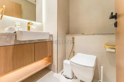 a bathroom with a white toilet and a sink at Skyline and Community Views 1BR with Private Balcony Near Community Park, Binghatti Amber, Jumeirah Village Circle by Deluxe Holiday Homes in Dubai