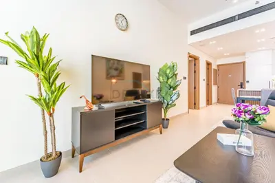 a living room with a table and some plants at Skyline and Community Views 1BR with Private Balcony Near Community Park, Binghatti Amber, Jumeirah Village Circle by Deluxe Holiday Homes in Dubai