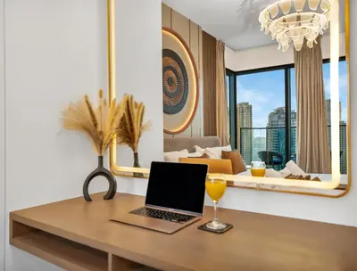 a desk with a laptop and a glass of orange juice at Vida Yacht Club # Up-scale 2BHK # Marina,Sea & Ain View in Dubai