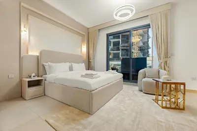 a bedroom with a bed and a chair and a window at Modern Compact Studio in JVC in Dubai