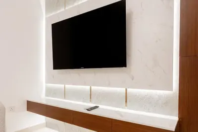 a flat screen tv on a wall in a bathroom at Modern Compact Studio in JVC in Dubai