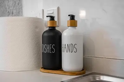 two bottles sitting on a counter next to a sink at Modern Compact Studio in JVC in Dubai