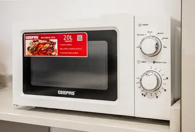 a microwave on a shelf with a sign on it at Modern Compact Studio in JVC in Dubai