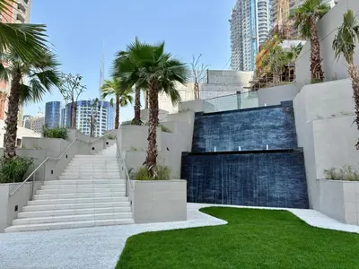 a stairway with palm trees in front of a building at Luxury 1BR in Downtown Dubai with Burj Khalifa Views, Pool, Gym & Free Parking in Dubai