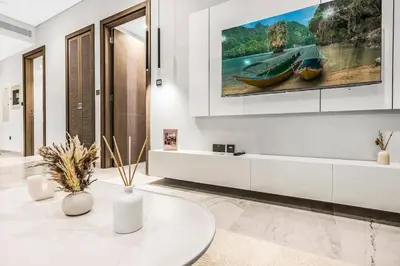 a living room with a tv on the wall at Luxury 1BR in Downtown Dubai with Burj Khalifa Views, Pool, Gym & Free Parking in Dubai