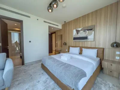 a bedroom with a large bed and a chair at Elegant 2-BR with modern comfort in Dubai