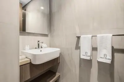 a bathroom with a white sink and a mirror at Luxury 1BR in Business Bay with Burj Khalifa Views, Balcony, Pool and Gym Access in Dubai