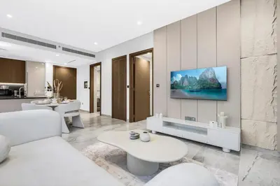 a living room with a tv on a wall at Luxury 1BR in Business Bay with Burj Khalifa Views, Balcony, Pool and Gym Access in Dubai