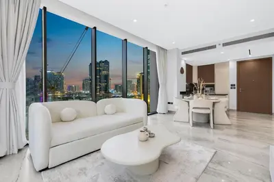 a living room with a white couch and a table at Luxury 1BR in Business Bay with Burj Khalifa Views, Balcony, Pool and Gym Access in Dubai