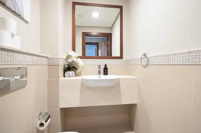 a bathroom with a sink and a mirror at 4BR Luxury Apartment with Burj Khalifa View and Direct Dubai Mall Access - Pool and PS5 Included in Dubai