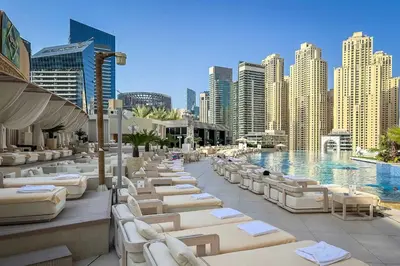 a resort with a pool and lounge chairs and buildings at Cinematic View Studio - Emaar Residences in Dubai