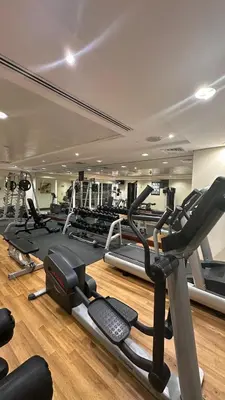 a gym with a lot of treadmills and machines at Modern Studio with Balcony - Close to Metro & Marina in Dubai