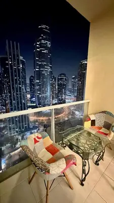 a balcony with a table and chairs and a view of a city at Modern Studio with Balcony - Close to Metro & Marina in Dubai
