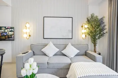 a living room with a gray couch with pillows at Luxury Studio in Dubai Marina with Canal views in Dubai
