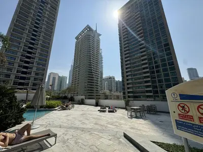 a woman laying on a chair in a pool with buildings at Luxury Studio in Dubai Marina with Canal views in Dubai
