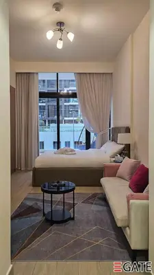 a bedroom with a bed and a couch and a table at EGATE - Studio - 1st Floor with Terrace - Dubai - 31-109 in Dubai