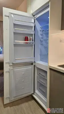 an empty refrigerator with its door open in a kitchen at EGATE - Studio - 1st Floor with Terrace - Dubai - 31-109 in Dubai