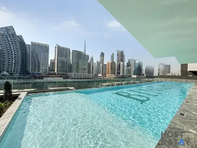 a large swimming pool with a city skyline in the background at Cozy Studio in Binghatti Canal - Close to Downtown in Dubai