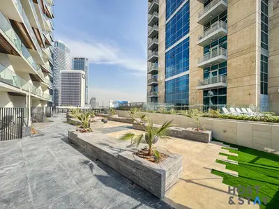 a building with a courtyard with palm trees on it at Cozy Studio in Binghatti Canal - Close to Downtown in Dubai