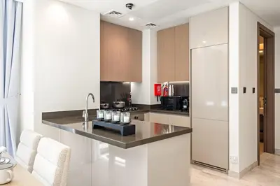a kitchen with a counter and a refrigerator at Luxe 2BR Retreat, Canal Views & Prime Dubai Stay Near Attractions in Dubai