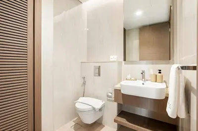 a white bathroom with a toilet and a sink at Luxe 2BR Retreat, Canal Views & Prime Dubai Stay Near Attractions in Dubai