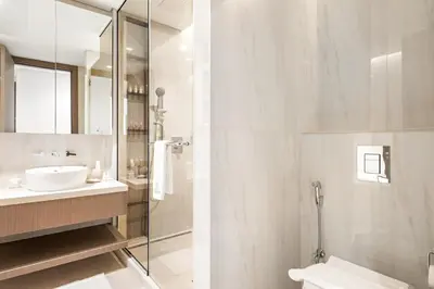 a bathroom with a sink and a toilet and a mirror at Luxe 2BR Retreat, Canal Views & Prime Dubai Stay Near Attractions in Dubai