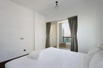 a bedroom with a white bed and a window at Livbnb-Upgraded 3B with Marina View,Near Promenade in Dubai