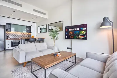 a living room with two couches and a table at Fresh & Stylish 2br Living At Collective Tower 1 in Dubai