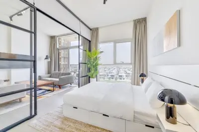 a bedroom with a white bed and a large window at Fresh & Stylish 2br Living At Collective Tower 1 in Dubai