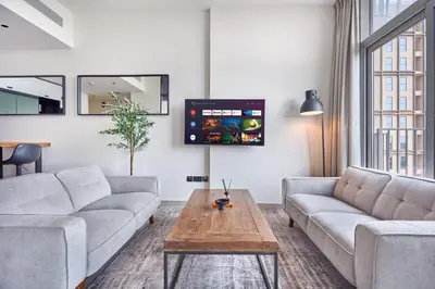 a living room with two couches and a tv at Fresh & Stylish 2br Living At Collective Tower 1 in Dubai