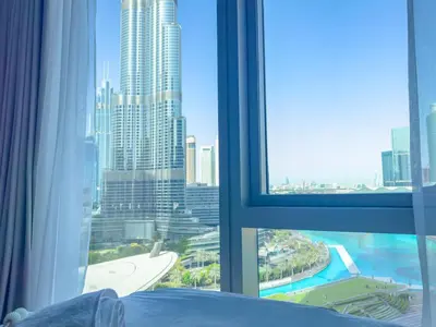 a bedroom with a view of a city from a window at GRANDE SIGNATURE with a direct Burj Khalifa view and Private Fountain Show with DXB AIRPORT VIP Shuttle option for 8 guests in Dubai