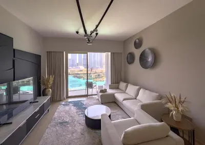 a living room with a couch and a tv at GRANDE SIGNATURE with a direct Burj Khalifa view and Private Fountain Show with DXB AIRPORT VIP Shuttle option for 8 guests in Dubai