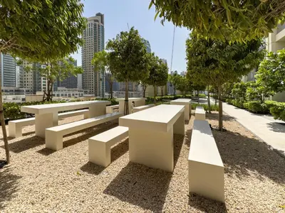 a row of white benches in a park at Panoramic Burj Khalifa Views at Burj Royale by Propigo in Dubai