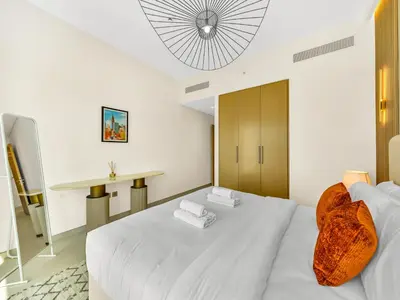 a bedroom with a white bed and a table at Panoramic Burj Khalifa Views at Burj Royale by Propigo in Dubai