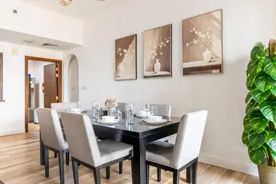 a dining room with a black table and chairs at Luxe Marina View Retreat! 2BDRM in Dubai
