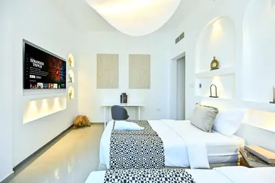 a bedroom with two beds and a flat screen tv at Black & Bold - Aesthetic Stay in Dubai