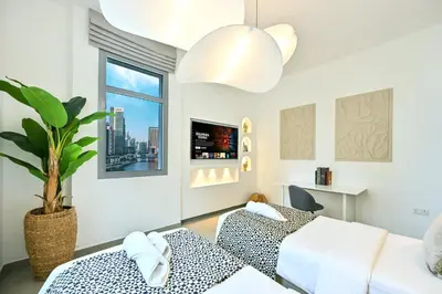 a bedroom with two beds and a potted plant at Black & Bold - Aesthetic Stay in Dubai